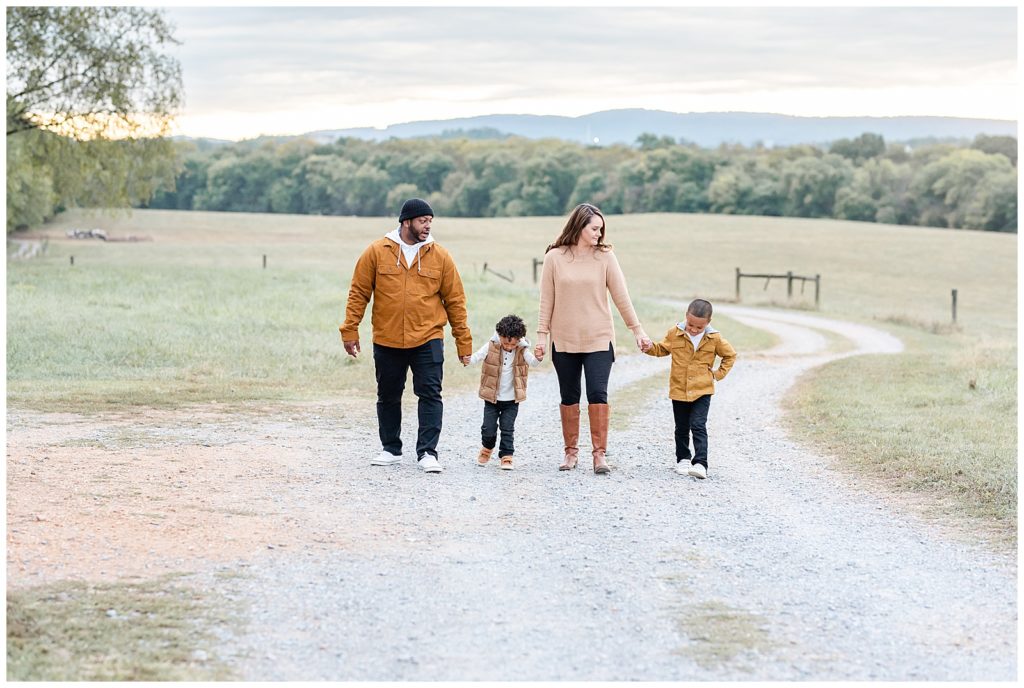 a cute family walks on a gravel road in a fall family session